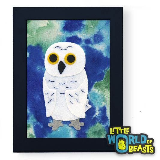 Framed artwork of a white owl on a blue and green watercolor style print background 